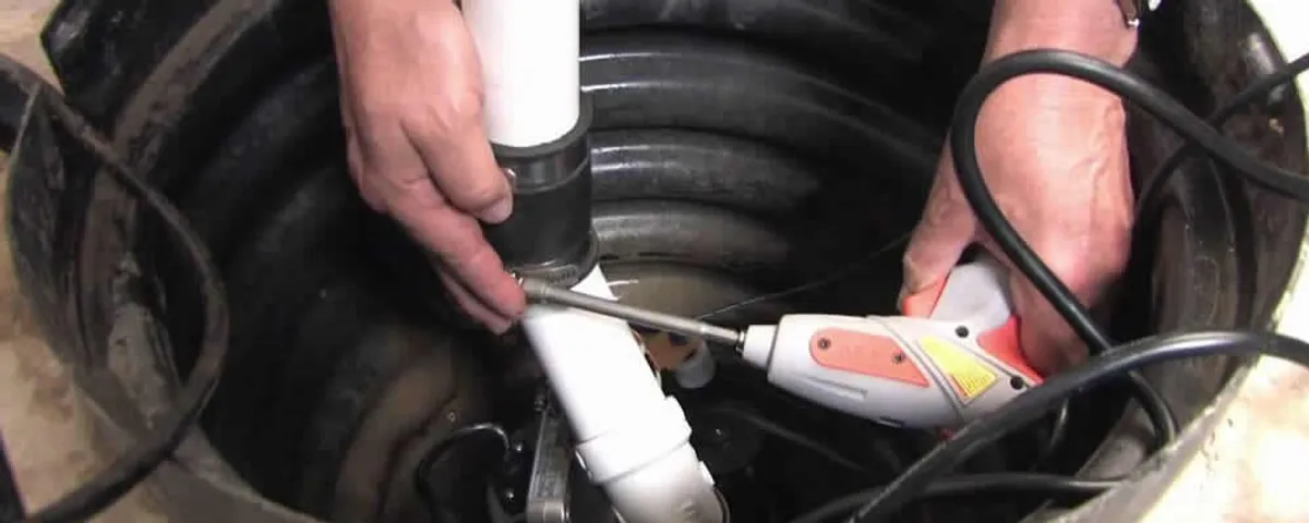 Sump pump installation technician connecting PVC discharge piping in Colorado Springs, CO